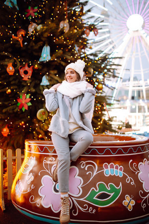 Young woman with caramel apple on Christmas market. Smiling woman in winter style clothes posing.の写真素材