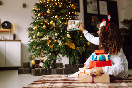 Portrait of young woman in santa claus hat with gift at the Christmas tree. Christmas. new year's.の写真素材