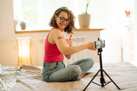 Woman blogger videotapes her vlog at home and speaking about Vaccine for covid-19.の写真素材