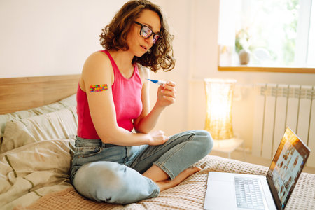 Woman blogger videotapes her vlog at home and speaking about Vaccine for covid-19.の写真素材