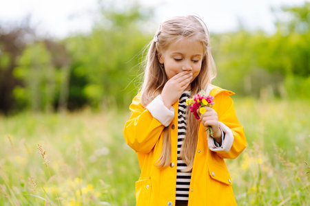 Cute little girl picking wildflowers in the meadow. A child explore nature.の写真素材