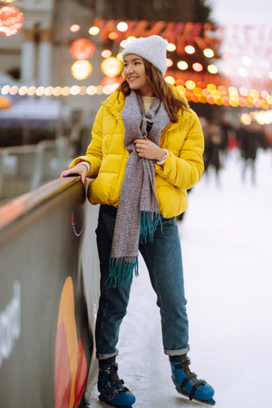 Happy woman ice skating on the ice arena in the city square on Festive Christmas fair. cold weather.の写真素材