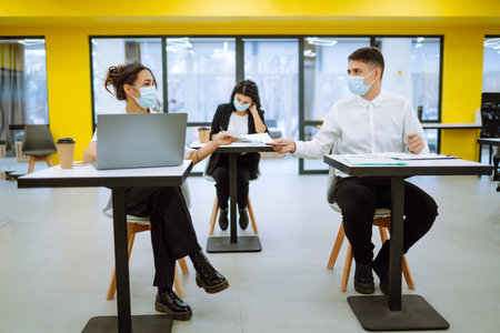 Business team people in protective face mask brainstorm on corporate project together write strategyの写真素材