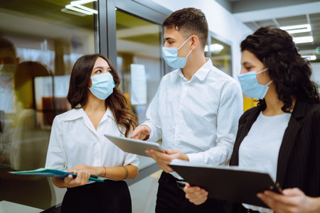 Business team people in protective face mask brainstorm on corporate project together write strategyの写真素材