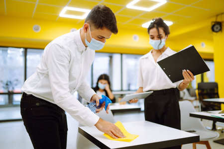 Office worker wearing face mask for social distancing for virus prevention while using laptop.の写真素材