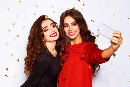 nice portrait of two happy young women in santa claus hat with gift .Christmas concept.の写真素材