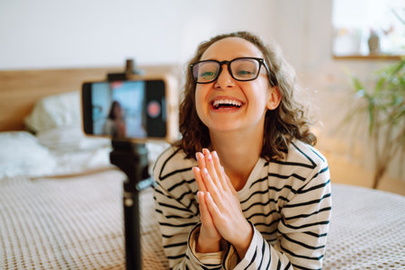fashion blogger. Young woman blogger talking with followers, live streaming and showing yellow sweater.の写真素材