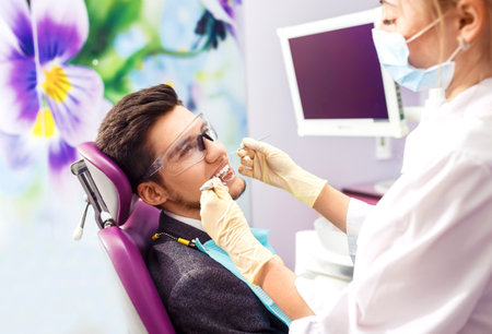 portrait of male. Dental Care Concept. Dental inspection is being given to Beautiful man surrounded by dentistの写真素材