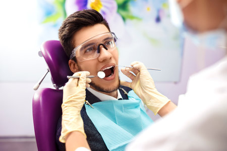 portrait of male. Dental Care Concept. Dental inspection is being given to Beautiful man surrounded by dentistの写真素材