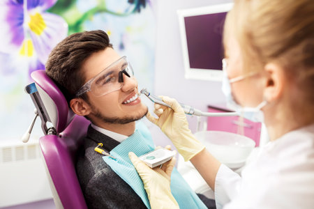 portrait of male. Dental Care Concept. Dental inspection is being given to Beautiful man surrounded by dentistの写真素材