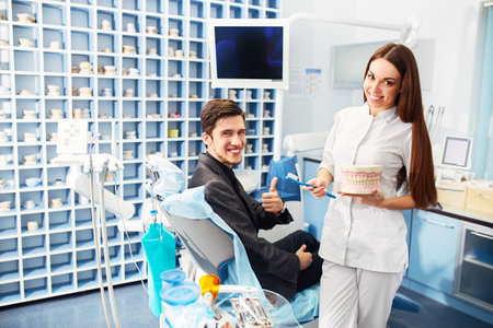 Professional woman dentist doctor working. Man at dental clinic. man at dentist taking care of teeth.の写真素材