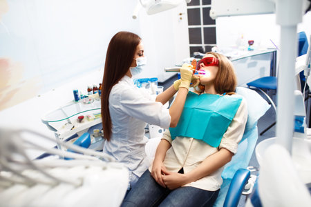 Overview of dental caries prevention. Woman at the dentist's chair during a dental procedure. Healthy Smile.の写真素材