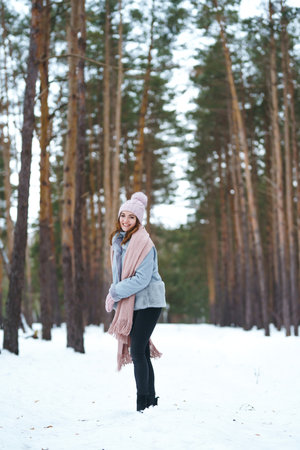 Cute young woman is playing with snow in the forest. Winter lifestyle happiness emotions nature.の写真素材