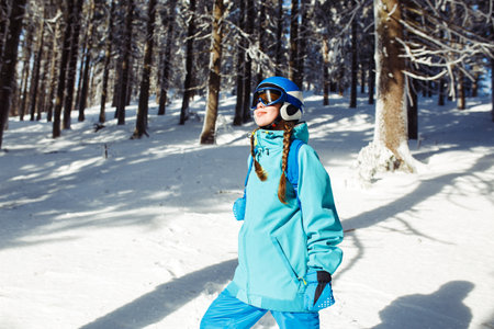 Girl in winter clothes drinking tea on the background of snow-capped mountains on the sunny day.の写真素材