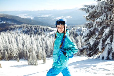 Girl in winter clothes drinking tea on the background of snow-capped mountains on the sunny day.の写真素材
