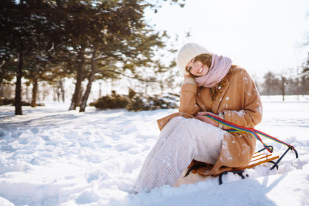 Happy woman walking in the snowy winter day outdoor. Winter fashion, holidays, rest, travel concept.の写真素材