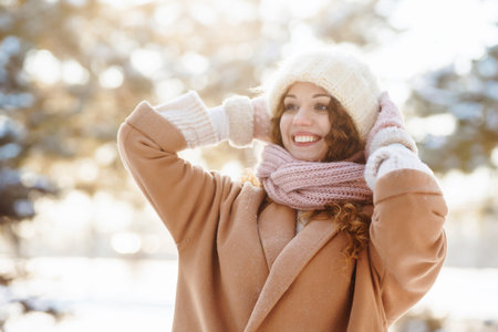 Happy woman walking in the snowy winter day outdoor. Winter fashion, holidays, rest, travel concept.の写真素材