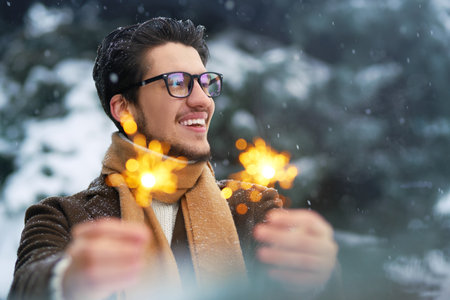 Outdoor close up portrait of young beautiful men. Smiling young man having fun outdoors. snowfall.の写真素材