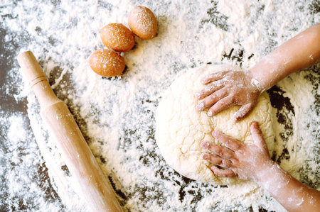 Children hands kneading dough for baking. Kids hands, some flour, wheat dough. Cookies for Christmas.の写真素材