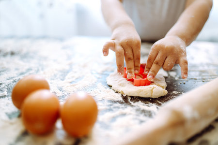 Children hands kneading dough for baking. Kids hands, some flour, wheat dough. Cookies for Christmas.の写真素材