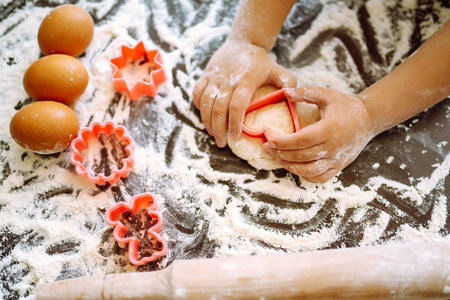 Children hands kneading dough for baking. Kids hands, some flour, wheat dough. Cookies for Christmas.の写真素材