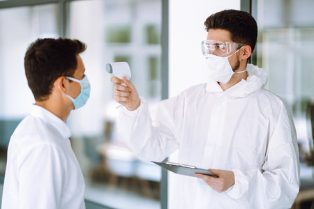 Disease control expert use an Infrared thermometer equipment to check the temperature.の写真素材