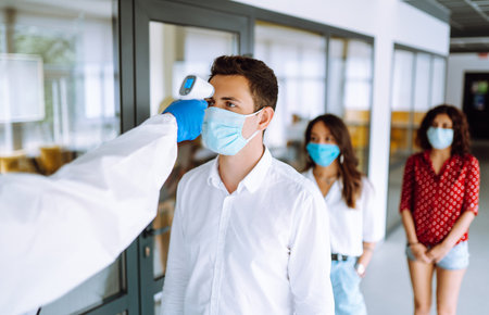 Visitors must go through measures using fever digital thermometer check temperature.の写真素材