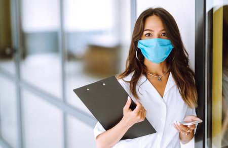 Office worker with face mask working in the office. Concept of preventing the spread of the epidemicの写真素材