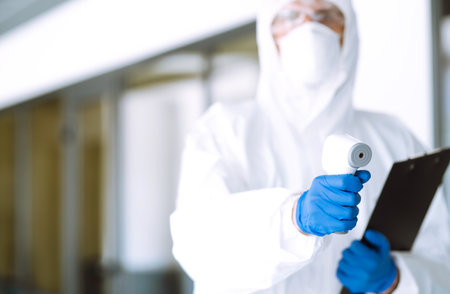 Disease control expert with an Infrared thermometer equipment to check the temperature.