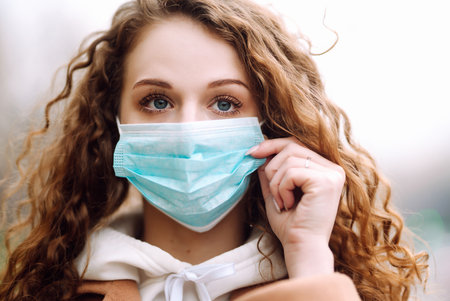 Woman in protective medical mask on her face on the street. Woman, wear face mask. corona virus.