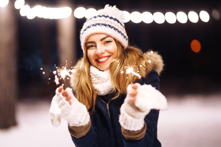 Happy young woman plays with a snow in sunny winter day. Girl enjoys winter, frosty day.の写真素材