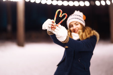 Happy young woman plays with a snow in sunny winter day. Girl enjoy winter, frosty day. playing with snow.の写真素材