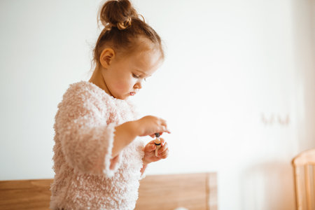 Happy little girl watching cartoons on phone lying in bed at home. happy loving family.の写真素材