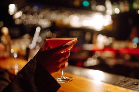 cocktail party. ?ocktail in the hands of a woman. Young woman drinking cocktails in bar.の写真素材