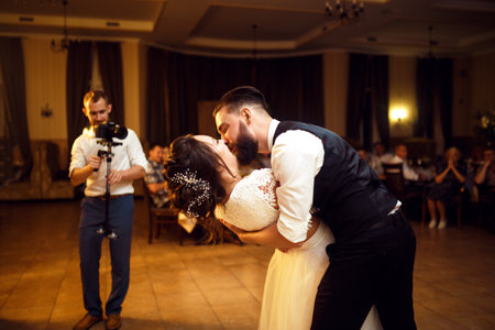 Happy bride and groom is cutting their stylish wedding cake on wedding banquet. Elegant and wedding cake.の写真素材