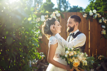 Stylish couple of happy newlyweds posing in the sun. Pretty bride and stylish groom. romantic moment.の写真素材