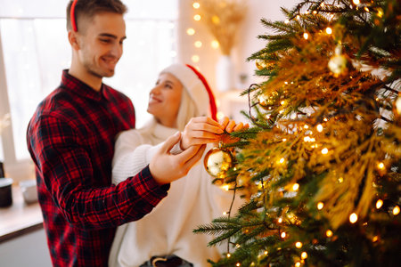 Young couple together celebrating christmas at decorated home. romantic day. winter holidays.の写真素材