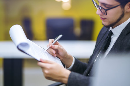 A man signs a contrac, legal or business agreements. Male hand with pen makes notes.の写真素材