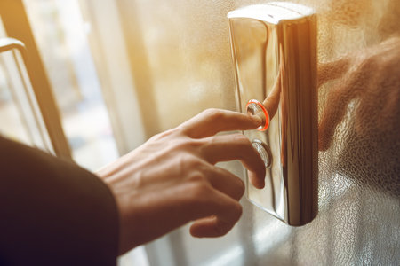 Man pressing elevator button. finger presses the elevator button. red button. sunset light.