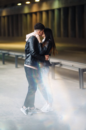 Young couple in love hug each other and kisses in underground crossing. love story.の写真素材