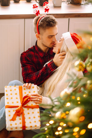 Young couple with Christmas gifts at home near Christmas tree. romantic day. holidays. New years.の写真素材