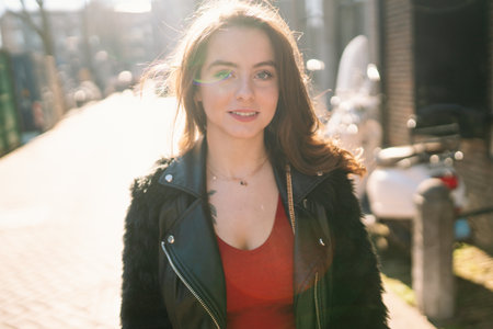 Portrait of a beautiful girl on a sunny day. Streets of Amsterdam. A girl enjoys her lifestyle.