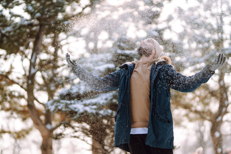 Portrait of young man in snowy winter forest. Season, christmas, travel and people concept.