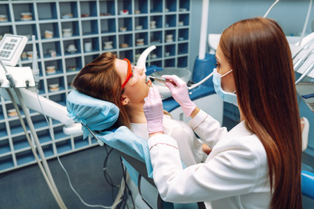Young woman at the dentist's chair during a dental procedure. Overview of dental caries prevention.の写真素材