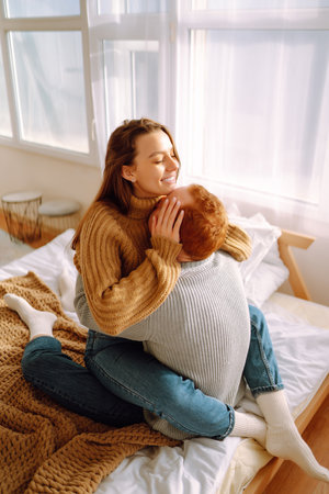 Couple in love relaxing at home on bed while they hug each other. Valentine's Day, holiday concept.の写真素材