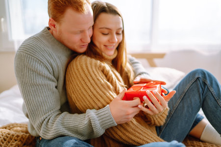 Valentine's day concept. Exchange of gifts. Young couple at home celebrating Valentine's Day.