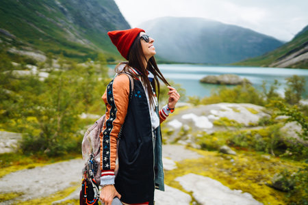 Stylish young woman enjoys freedom against the backdrop of the mountains in the Norway.の写真素材