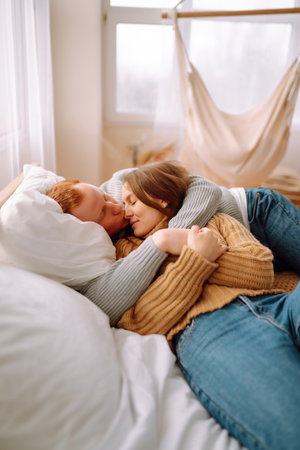 Couple in love relaxing at home on bed while they hug each other. Valentine's Day, holiday concept.の写真素材