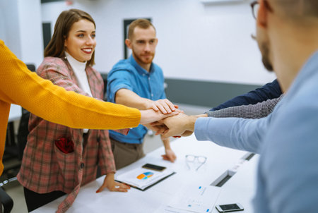 Young business people demonstrating unity with their own hands. stack of hands.