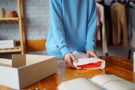 Close-up of preparing a parcel on the table. Woman online store, small business owner, entrepreneur.